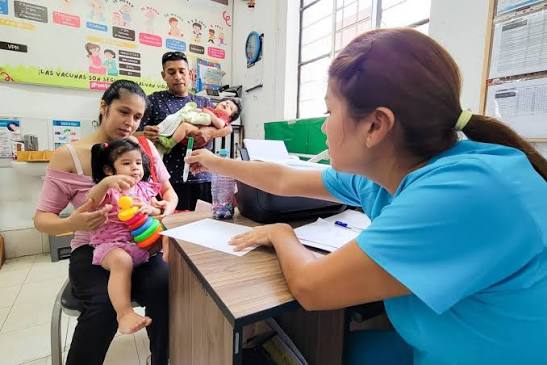 Enfermera realizando control CRED a un niño acompañado por su madre