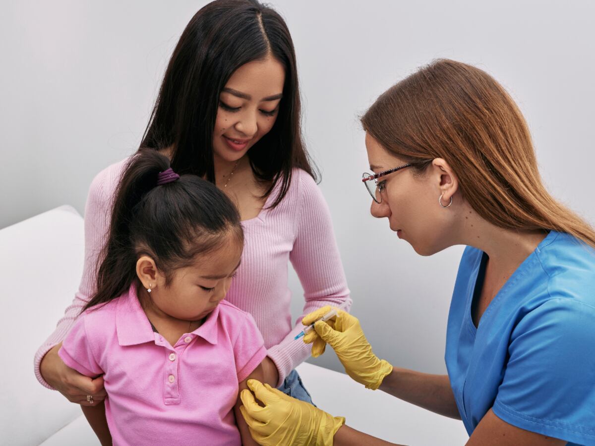 Profesional de salud vacunando a una niña